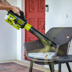 Person using the Sun Joe 48-volt cordless brushless turbine leaf blower to blow leaves off patio furniture.