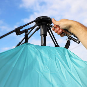 Close-up of a person assembling their beach tent.