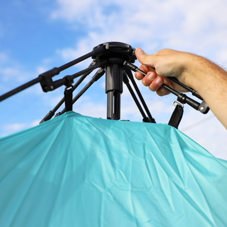 Close-up of a person assembling their beach tent.