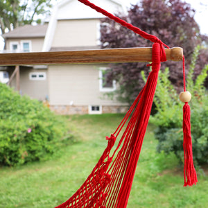 Close-up of the spreader bar and tassel on the Bliss Hammocks 40-inch Red Island Rope Hammock Chair.