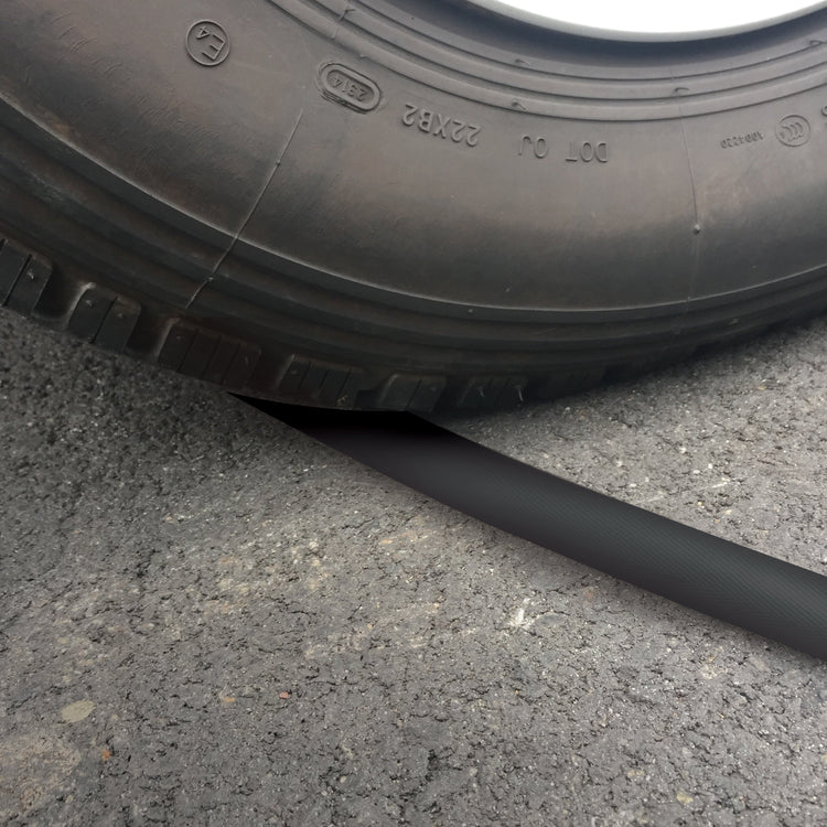 Car running over the Aqua Joe 75-foot non-expanding black fiberjacket hose.