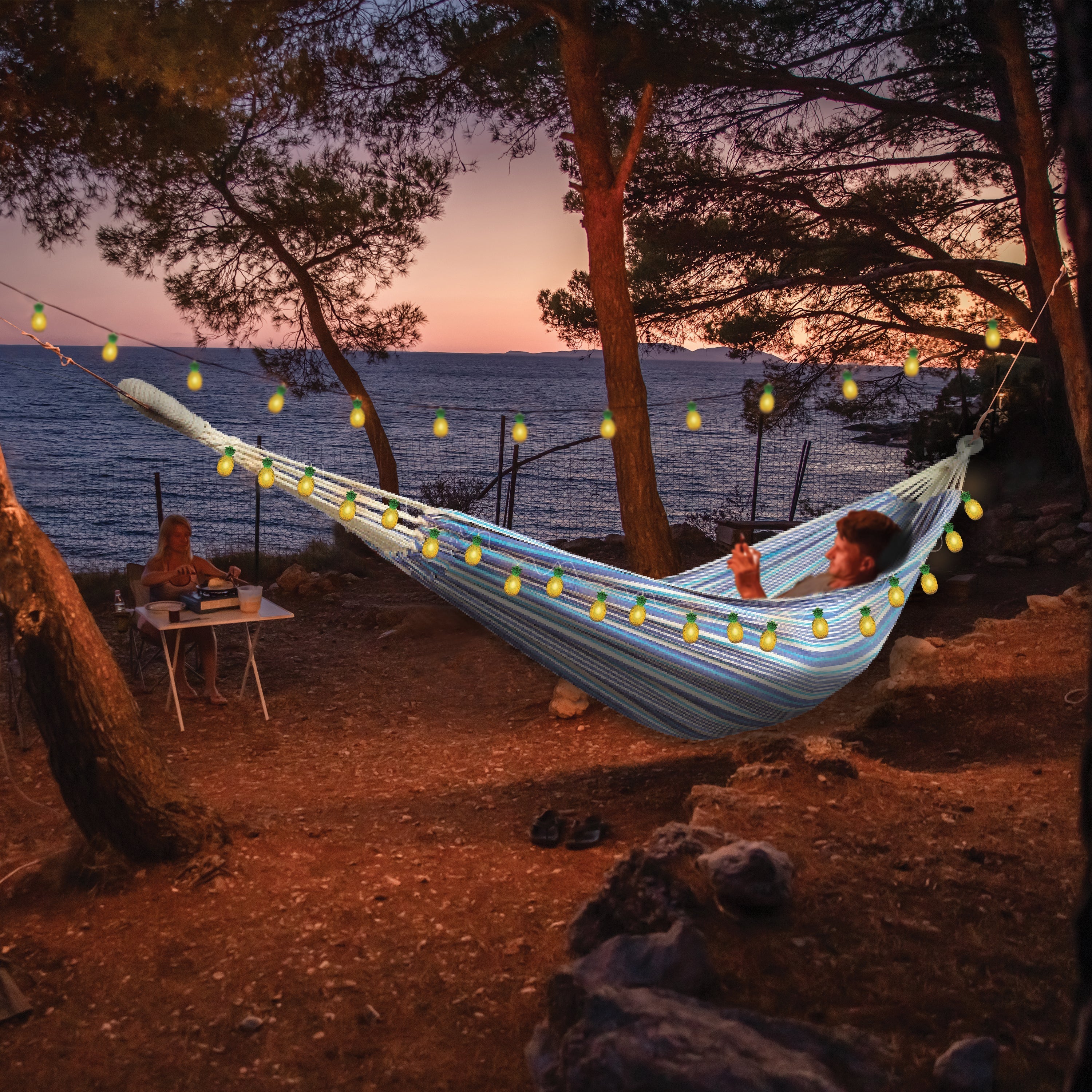 Person laying in a hammock at sunset with the strong lights hung around their hammock.