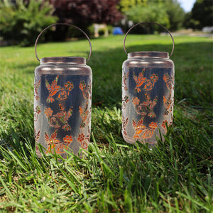 Set of 2 bronze LED lanterns on a lawn.