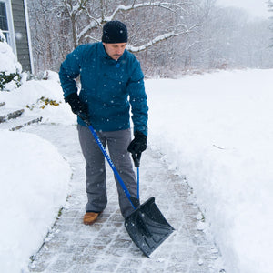 man shovelling snow off walkway with snow joe strain reducing shovel