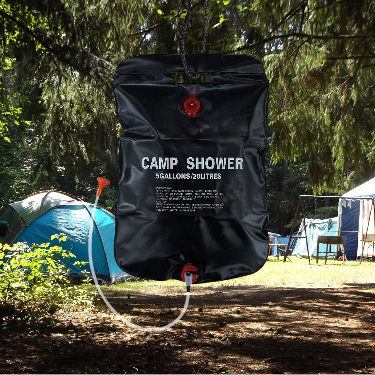 TrailGear 20-liter solar shower bag hanging from a tree with a camp in the background.